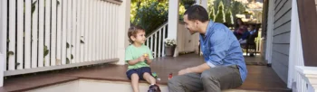 Dad and son sitting on the front porch of a house - Inspect-All Services Pest Control in Atlanta, GA